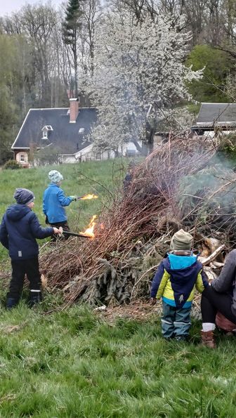 Das Feuer wir mit Fackeln angezündet, die Kinder sind begeistert